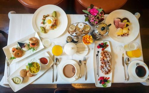 a table with plates of breakfast food on it at Taj 51 Buckingham Gate Suites and Residences in London