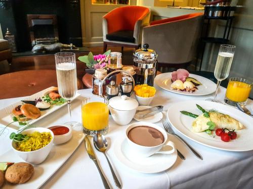 a table with plates of breakfast foods and drinks at Taj 51 Buckingham Gate Suites and Residences in London