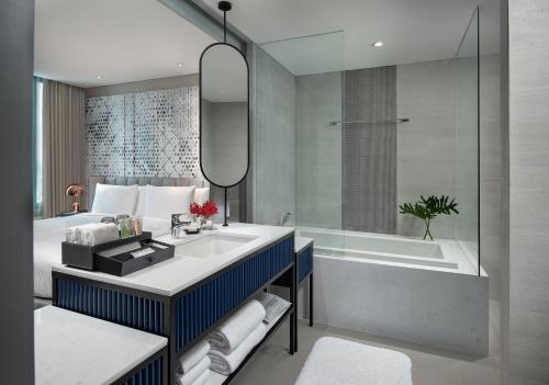 een badkamer met een wastafel en een bad bij Avani Sukhumvit Bangkok Hotel in Bangkok