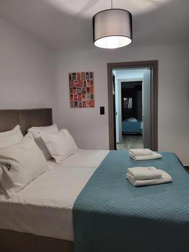 a bedroom with a large bed with two towels on it at White Boutique Homes - Serenity in Metókhion Apisianá