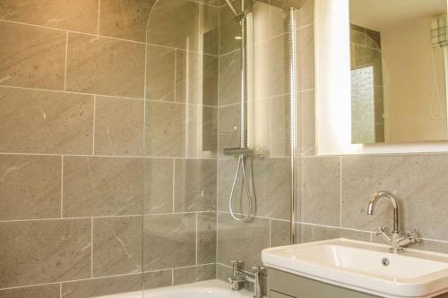 a bathroom with a sink and a shower at Edge View Cottage in Church Stretton