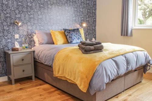 a bedroom with a bed with a yellow blanket at Edge View Cottage in Church Stretton