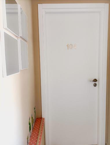 a hallway with a white door and a red and white tile floor at Villemar in Isola delle Femmine