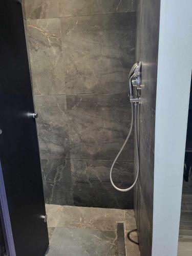 a shower with a hose in a bathroom at White Boutique Homes - Serenity in Metókhion Apisianá