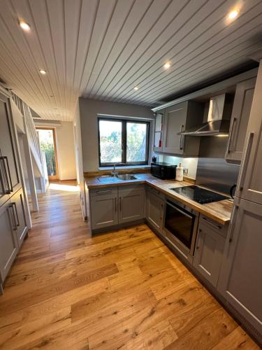 cocina con armarios grises y suelo de madera en Mulberry Barn located in the South Downs National Park en Ditchling