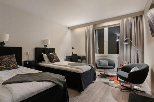 una habitación de hotel con 2 camas y una silla en Quality Hotel Vänersborg en Vänersborg