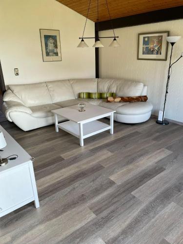 a living room with a white couch and a table at Ferienpark Fedderwardersiel in Fedderwarderdeich