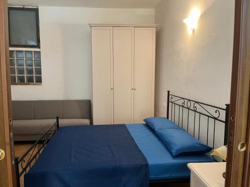 a bedroom with a bed with blue sheets and a couch at La Dimora del RE in Gaeta
