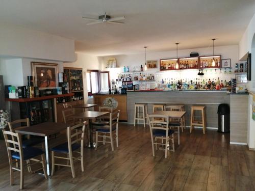 a bar with tables and chairs in a restaurant at Malì Trevignano Piccolo Hotel in Trevignano Romano