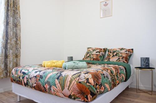- un lit avec une couette et des oreillers colorés dans l'établissement Le CosyCatala - 3 personnes - bureau & wifi, à Perpignan