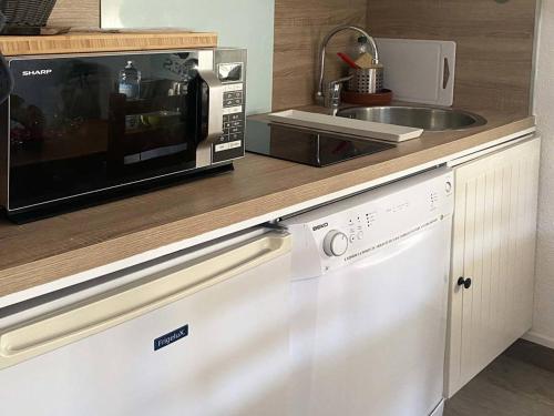 La cuisine est équipée d'un four micro-ondes et d'un lave-vaisselle. dans l'établissement Grand studio rénové, skis aux pieds, idéal famille, 6 pers, Les Orres - FR-1-322-469, aux Orres