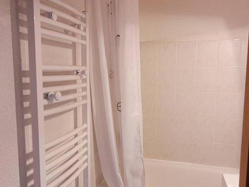 La salle de bains est pourvue d'une douche avec rideau de douche blanc. dans l'établissement Location 2 pièces cabine mezzanine à Saint-Jean-d'Aulps, pied de pistes, parking, animaux admis - FR-1-573-29, à Saint-Jean-dʼAulps