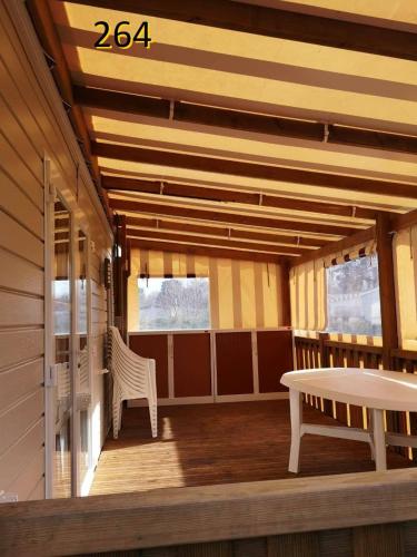 a room with a table and a bench on a porch at davorel mobil home in Les Mathes
