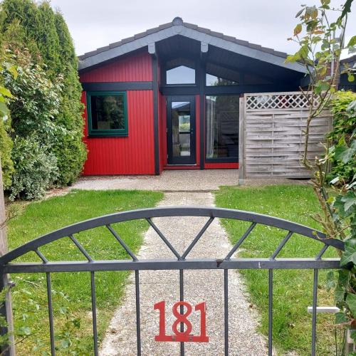 a red house with a gate in front of it at Ferienpark Fedderwardersiel in Fedderwarderdeich