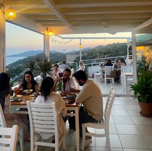 a group of people sitting at a table in a restaurant at Hideaway in Kas