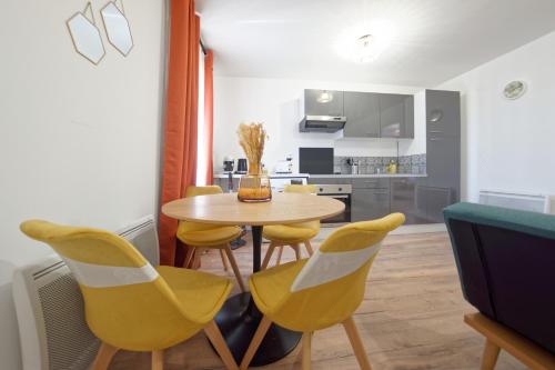une cuisine et une salle à manger avec une table et des chaises jaunes dans l'établissement Le Soleilcasa - 3 personnes - bureau & wifi, à Perpignan
