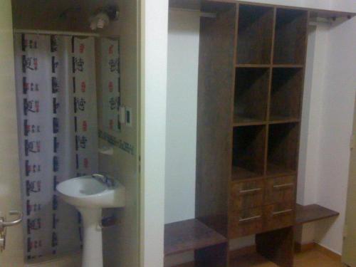 a bathroom with a sink and a toilet and a cabinet at HOSTEL RESIDENCIAL SAENZ PEÑA in Sáenz Peña