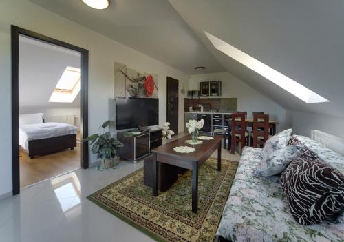 a living room with a couch and a table at JD Apartamenty - Klimatyzacja, basen, parking i wifi w cenie in Mysłakowice