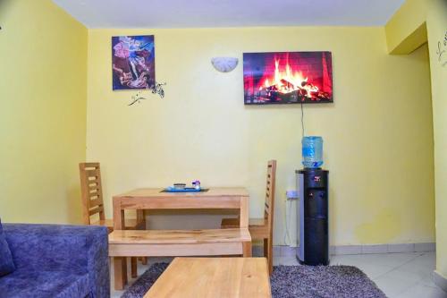 ein Wohnzimmer mit einem Tisch und einem Kühlschrank in der Unterkunft Four seventy in Meru