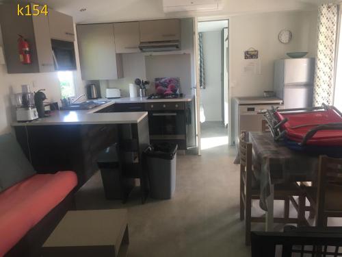 a kitchen with a counter top and a kitchen with a table at davorel mobil home in Les Mathes