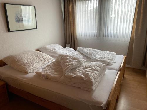 two unmade beds in a bedroom with a window at Ferienpark Fedderwardersiel in Fedderwarderdeich