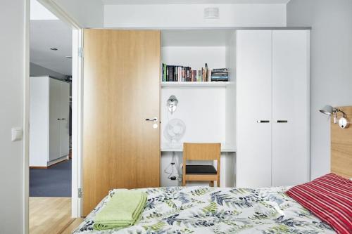 1 dormitorio con cama y armario de madera en Tasokas huoneisto kaupungin keskustassa. en Tampere
