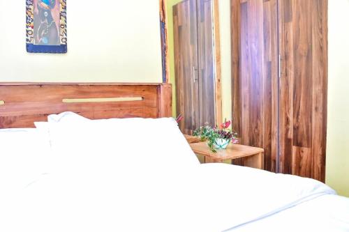 a bedroom with a bed with a wooden head board at Four seventy in Meru