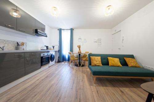 un salon avec un canapé vert et une table dans l'établissement Le Pyrénid - 3 personnes - bureau & wifi, à Perpignan