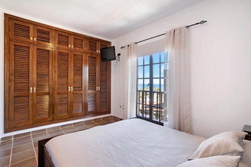 a bedroom with a bed and a large window at Residencial Maresia el Medano in El Médano