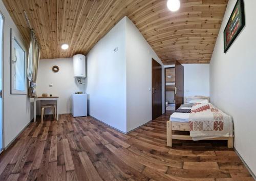 a bedroom with a bed and a wooden ceiling at Hanul Casa Alba Fehér Ház Fogadó in Periprava