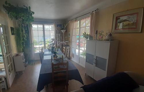 - un salon avec une table et un réfrigérateur blanc dans l'établissement O'jardin, à Arthez-de-Béarn