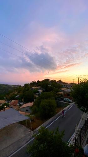 a person riding a bike down a road at sunset at Six blossoms ! in Exanthia