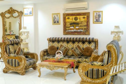 a living room with a couch and chairs at Grand Buana Lestari Hotel in Duku