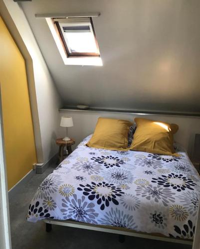 a bedroom with a bed with a blue and white comforter at Honfleur : Appartement de charme. in Honfleur