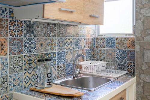 a kitchen with a sink and tiles on the wall at Private Voula Beach Suite in Athens