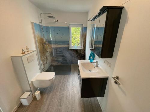 Un baño con lavabo, inodoro y espejo. en Ferienhaus Urlaubshafen, en Bremerhaven