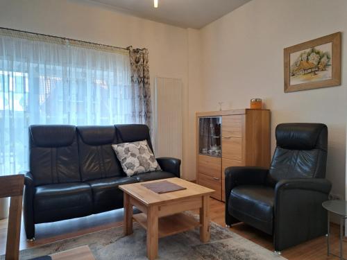 a living room with a leather couch and a table at Haus Waldek in Herzlake