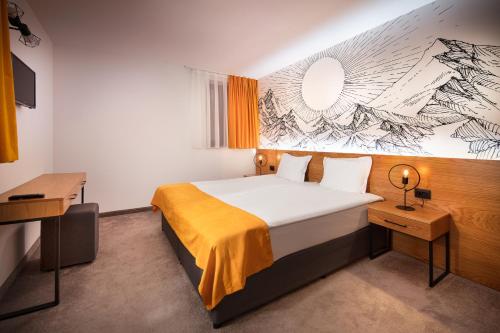 a hotel room with a bed and a painting on the wall at Hotel Alfaresort Thermal Chiflika in Chiflik