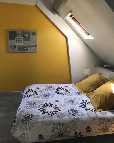 - une chambre avec un lit et un mur jaune dans l'établissement Honfleur : Appartement de charme., à Honfleur