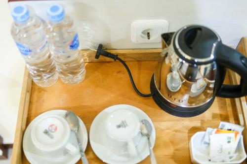 a tea kettle and two bottles of water on a table at Grand Buana Lestari Hotel in Duku