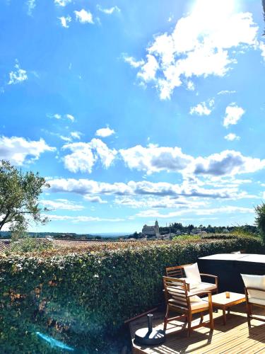two chairs and a table on a wooden deck at Chambre d'hôtes avec Jacuzzi Ventoux Cocoon in Bédoin