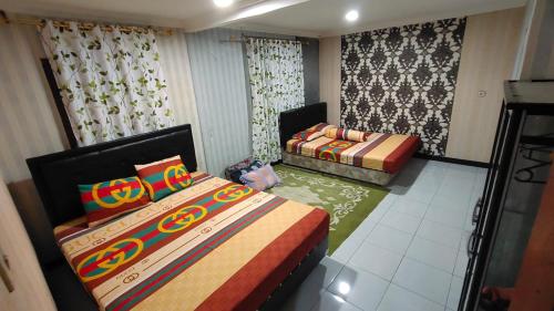 a room with two beds and a couch in it at Anugerah Homestay Playen in Siyonokulon