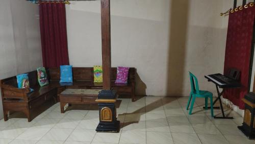 a living room with a table and chairs and a piano at Anugerah Homestay Playen in Siyonokulon