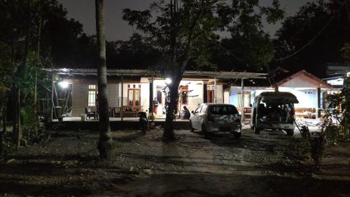 Siyonokulon的住宿－Anugerah Homestay Playen，两辆汽车晚上停在房子前面
