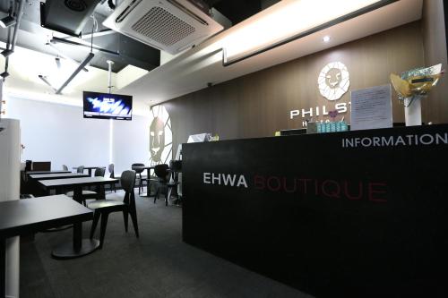 a restaurant with a sign that says philipsurance and tables and chairs at Philstay Ehwa Boutique - Female Only in Seoul