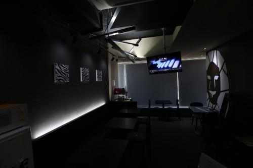 a dark room with a tv and chairs in it at Philstay Ehwa Boutique - Female Only in Seoul