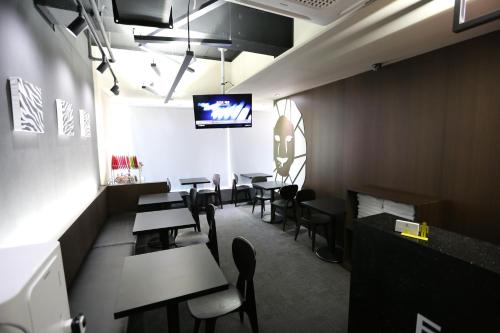 a dining room with tables and chairs and a flat screen tv at Philstay Ehwa Boutique - Female Only in Seoul