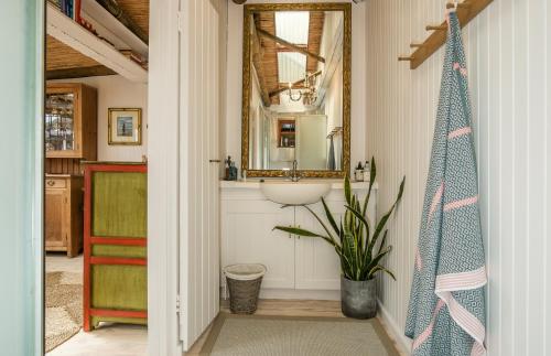 a bathroom with a sink and a mirror at Treetops Cottage in Cape Town