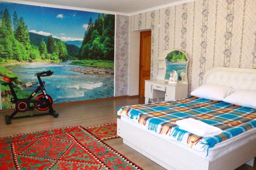 ein Schlafzimmer mit einem großen Gemälde eines Flusses in der Unterkunft Almaz Guesthouse Naryn in Orto-Saz