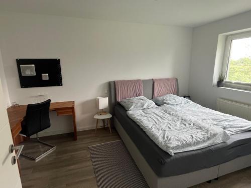 Dormitorio con cama, escritorio y TV en Ferienwohnung Katharon, en Tespe